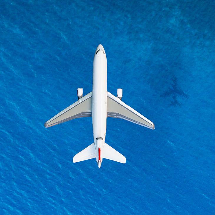 一架商业飞机从奥西恩上空飞过，在水面上投下一个影子