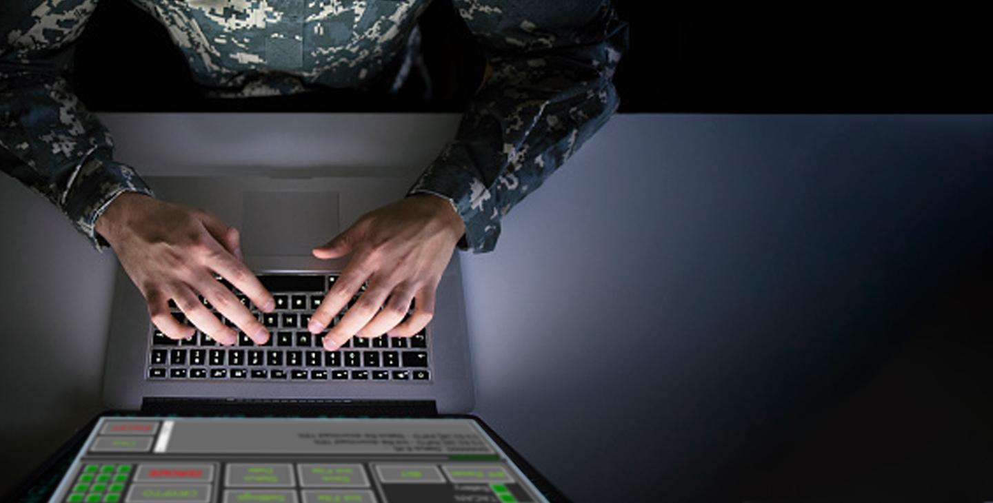 头顶上的一个男人穿着绿色军装在笔记本电脑上使用Link 16软件打字
